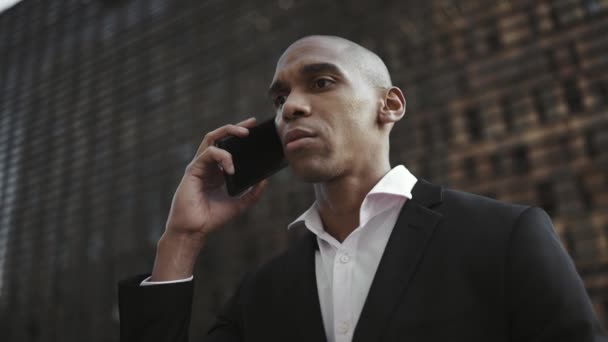 路上で携帯電話で話しているアフリカのビジネスマンを自信を持って — ストック動画