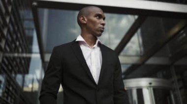 Açık havada yürüyen kendinden emin Afrikalı iş adamı