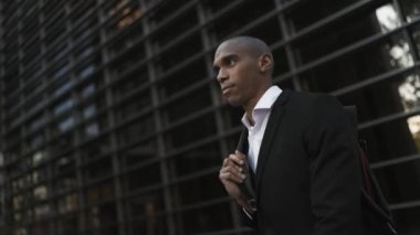 Şehirde yürüyen pozitif Afrikalı işadamı