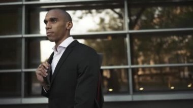 Meditasyon yapan Afrikalı işadamı şehirde yürüyor.