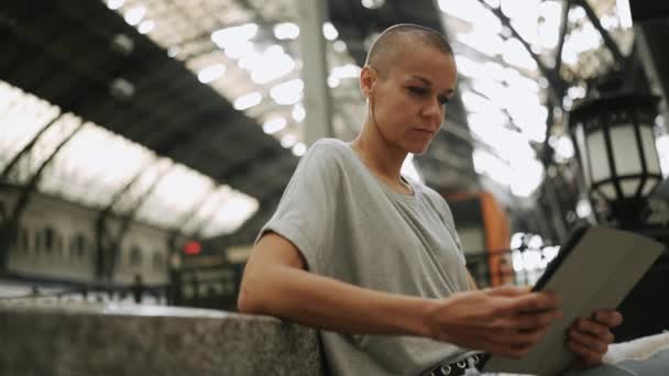 Mujer Calva Pensativa Con Camiseta Leyendo Libro Electrónico Banco — Vídeo de stock