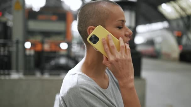 Tişört Giyen Telefonla Konuşan Tezgahta Parmağını Gösteren Kel Bir Kadın — Stok video
