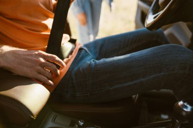 White man fastening seat belt while sitting in car