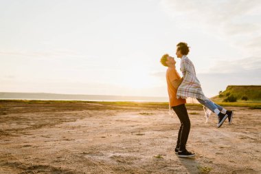 Genç, çok ırklı bir çift dışarıda eğlenirken gülüyor.