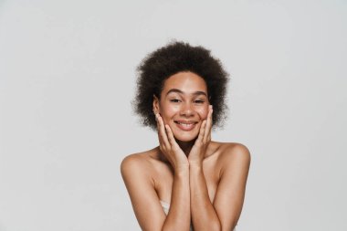 Siyah esmer kadın gülümsüyor ve beyaz arka planda izole edilmiş kameraya bakıyor.