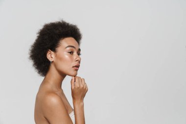 Black young curly woman posing and looking aside isolated over white background
