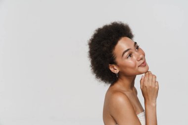 Siyah esmer kadın gülümsüyor ve yukarı bakıyor beyaz arka planda soyutlanmış.