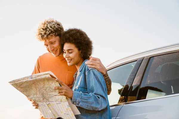 Young Multiracial Couple Smiling Examining Map Car Trip — Stock Fotó