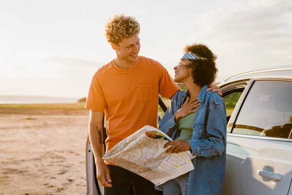 Young Multiracial Couple Laughing Examining Map Car Trip — Foto Stock