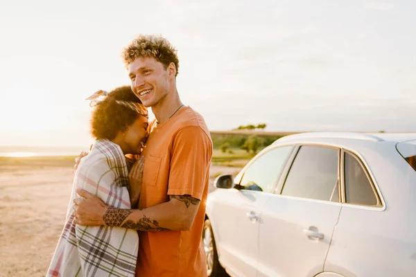 Νεαρό Πολυφυλετικό Ζευγάρι Γελάει Και Αγκαλιάζει Ενώ Στέκεται Αυτοκίνητο Κατά — Φωτογραφία Αρχείου