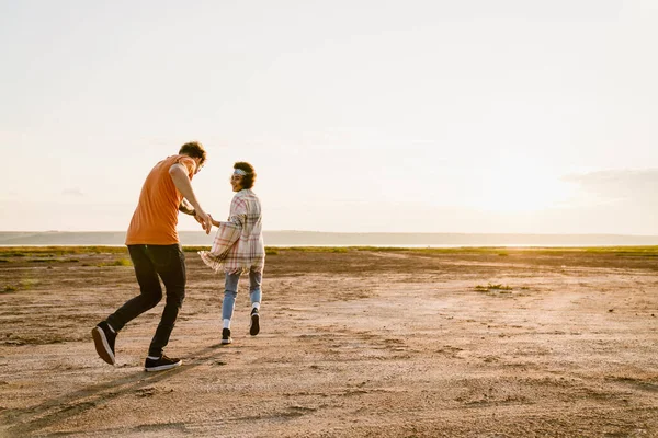 屋外で一緒に楽しみながら走る若い多人種カップル — ストック写真