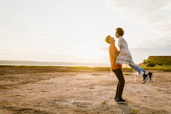 Genç, çok ırklı bir çift dışarıda eğlenirken gülüyor.