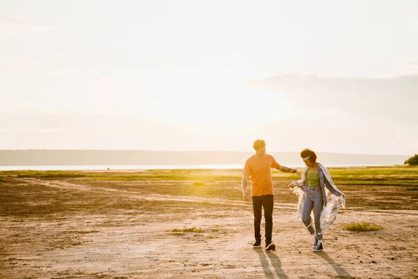 Young Multiracial Couple Smiling While Walking Together Outdoors — Stockfoto