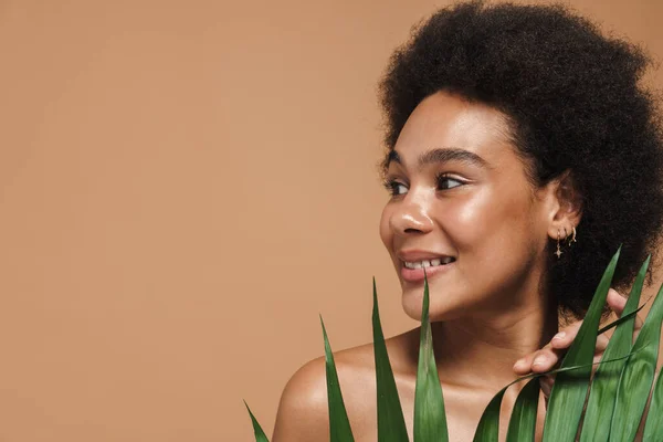 Bej Arka Planda Yeşil Yapraklı Poz Verirken Gülümseyen Siyah Tişörtsüz — Stok fotoğraf
