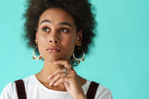 Küpe Takan Genç Siyahi Bir Kadın Mavi Arka Planda Yalnız — Stok fotoğraf