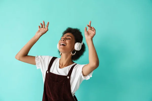 Black Young Woman Dancing While Listening Music Headphones Isolated Blue —  Fotos de Stock