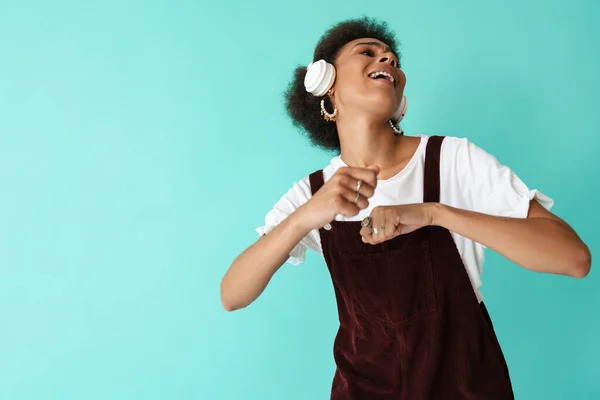 Black Young Woman Dancing While Listening Music Headphones Isolated Blue — Stockfoto