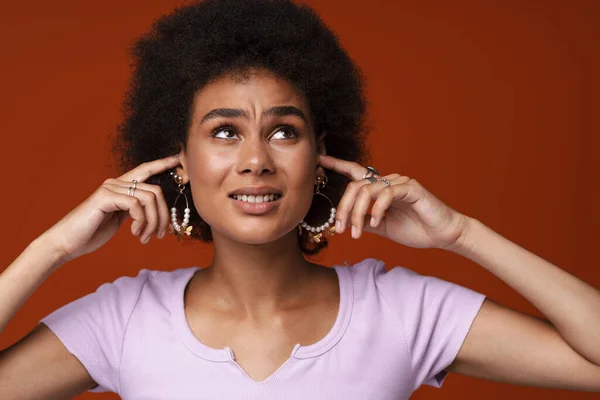 Young Black Woman Wearing Earrings Frowning While Plugging Her Ears — ストック写真