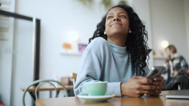 Mujer Africana Feliz Usando Suéter Azul Mensajes Texto Teléfono Mirando — Vídeos de Stock