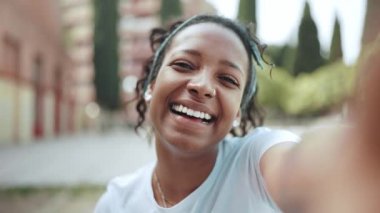 Smiling brunette African woman blowing air kiss at the camera outdoors