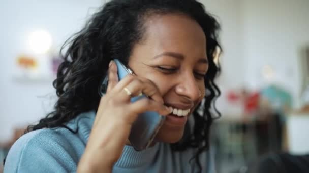 Uśmiechnięta Afrykanka Niebieskim Swetrze Rozmawiająca Przez Telefon Kawiarni — Wideo stockowe