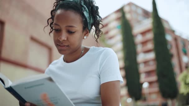 多愁善感的黑发非洲女人在户外看书 — 图库视频影像