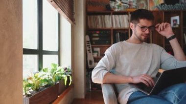 Ofiste dizüstü bilgisayarla yazan gülen adam.