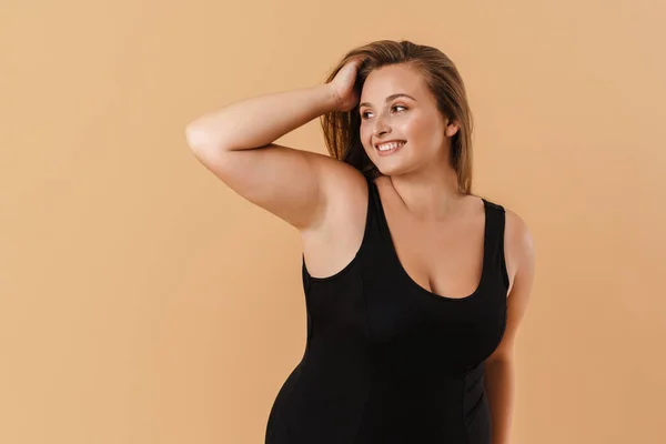 Young Woman Wearing Swimsuit Smiling Looking Aside Isolated Beige Background — стоковое фото