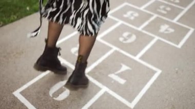 Woman playing hopscotch outdoors