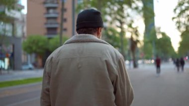 Şehirde yürüyen şapkalı yakışıklı bir adam.