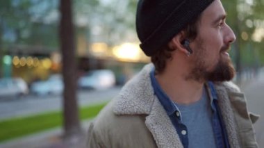 Şehirde şapka takıp müzik dinleyen komik bir adam.