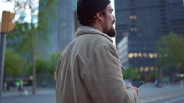 Şehirde duran şapkalı olumlu bir adam.