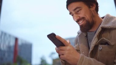 Dışarıdaki telefonlara bant yapıştırarak gülen adam.