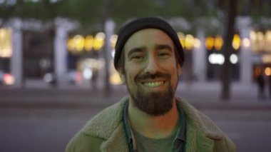 Akşamları şapkalı neşeli adam kameraya bakıyor.