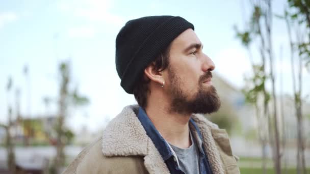 Handsome Bearded Man Wearing Hat Walking Smoking Outdoors — стоковое видео