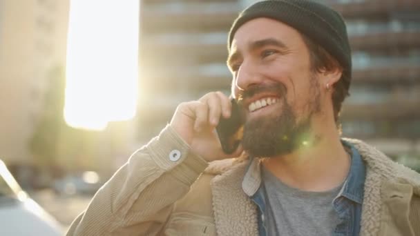 Positive Bearded Man Wearing Hat Talking Phone Outdoors — Stock video