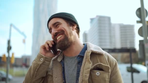 Smiling Bearded Man Wearing Hat Talking Mobile City — Stock video