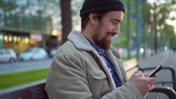 Cheerful Man Wearing Hat Texting Phone City — стоковое видео