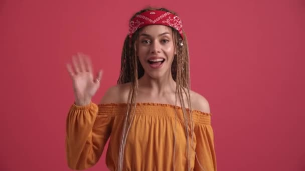 Smiling Hippie Woman Doing Hello Gesture Camera Pink Studio — Stockvideo