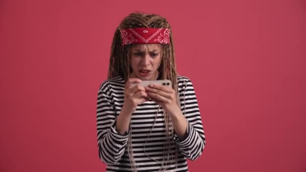 Sad Hippie Woman Playing Digital Game Phone Pink Studio — Stockvideo