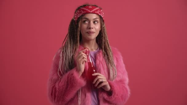 Glimlachende Hippie Vrouw Positief Schudden Hoofd Iets Drinken Roze Studio — Stockvideo
