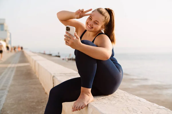 Ginger Young Woman Gesturing Using Cellphone Yoga Practice Outdoors — стоковое фото