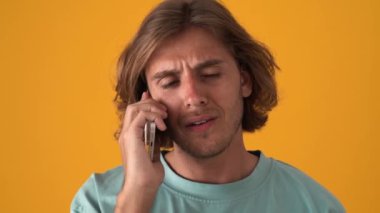 Sarı stüdyoda telefonla konuşan güzel sarışın adam.