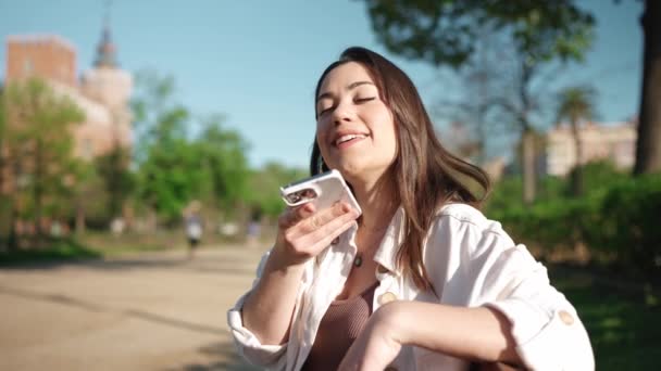 Csinos Barna Rögzít Hangüzenetet Mobilon Miközben Padon — Stock videók