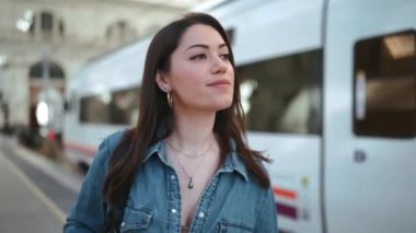 Gülümseyen esmer kadın turist platformda sırt çantasıyla yürüyor.