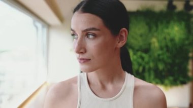 İçerideki kameraya bakan konsantre olmuş esmer kadın.