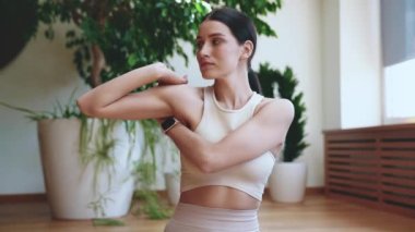 Kendine güveni tam esmer kadın. Pencere kenarında yoga yapmadan önce ellerini uzatıyor.