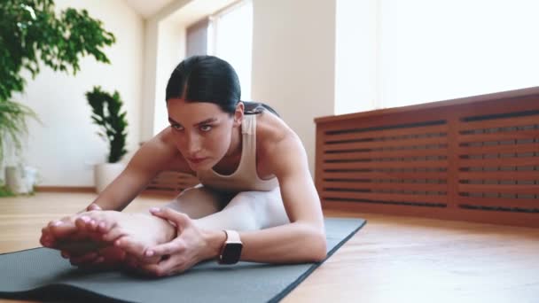 Sportif Ciddi Genç Bir Kadın Yoga Minderinde Esneme Egzersizi Yapıyor — Stok video
