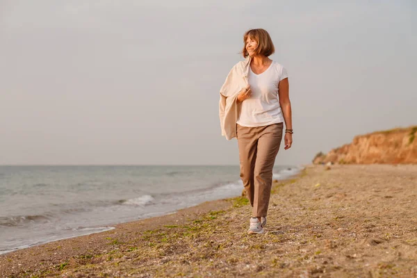 Senior European Woman Smiling While Walking Sandy Beach — Stock Photo, Image