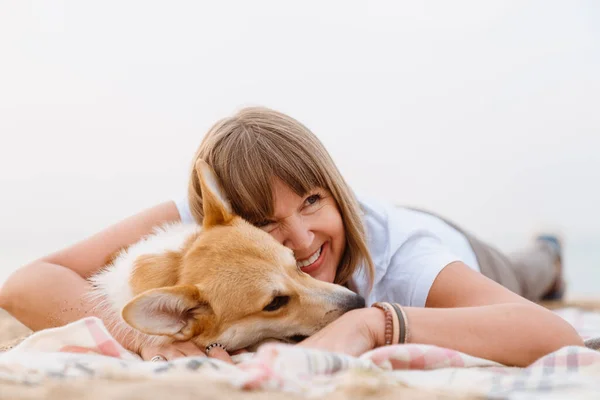 Seniorin Lächelt Während Sie Mit Ihrem Hund Sandstrand Ruht — Stockfoto